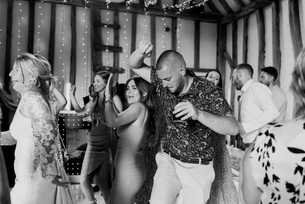 wedding guests and bridge dancing on the dance floor in black and white image - wedding DJ Essex